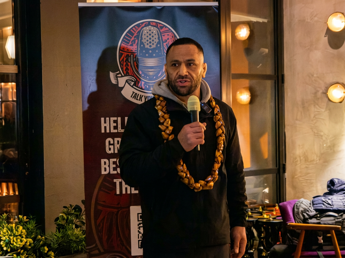 Keynote speaker on stage under a spotlight addressing a large audience